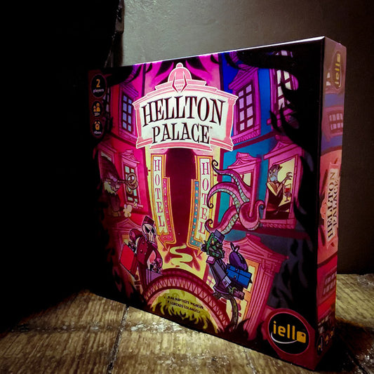 Featured image of the Hellton Palace game box on a wooden table, in front of a dark grey wall. Image exclusively on the Kaioss Games blog